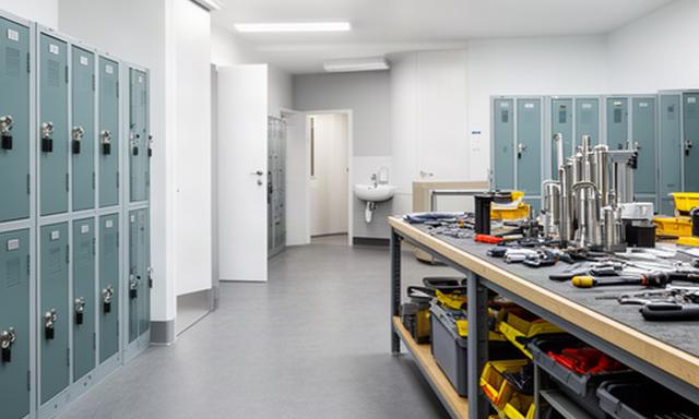 Clean staff support area with durable flooring, lockers, washroom access and a maintenance workbench